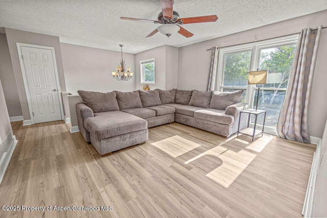 830 Exmoor Rd, Craig, CO 81625 - living area featuring a chandelier, light wood-style flooring, a textured ceiling, a ceiling fan, and baseboards