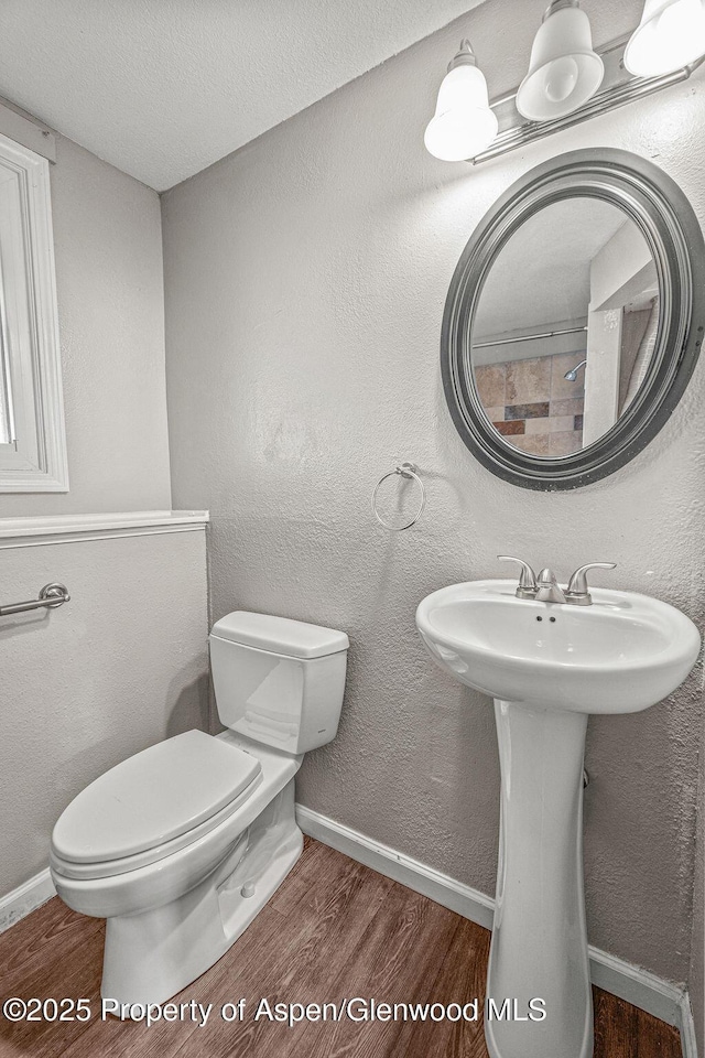 830 Exmoor Rd, Craig, CO 81625 - bathroom featuring wood finished floors, toilet, and baseboards