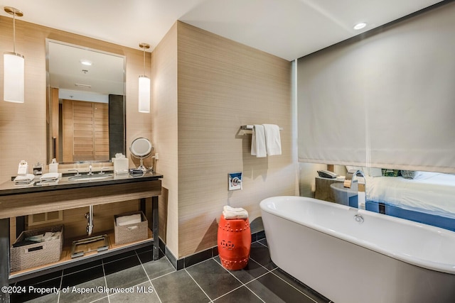 bathroom featuring tile patterned floors, vanity, a bathing tub, and tile walls