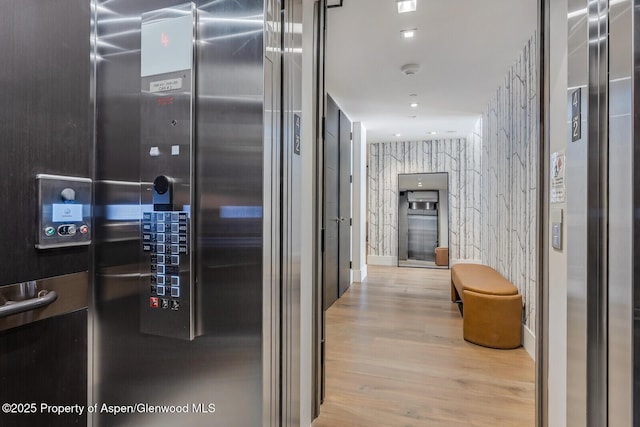 hallway featuring elevator and wood finished floors