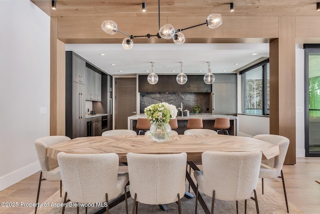 dining room featuring light wood finished floors and baseboards