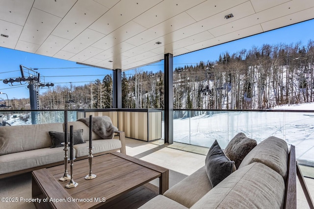 snow covered patio featuring a balcony and an outdoor hangout area
