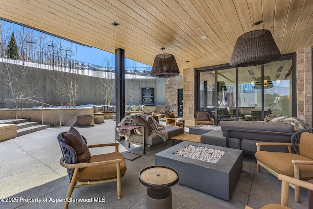 view of patio featuring an outdoor living space with a fire pit and fence