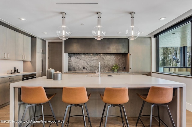 kitchen featuring light countertops, tasteful backsplash, a sink, and modern cabinets