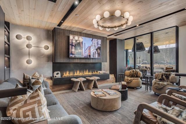 cinema room featuring wood finished floors, visible vents, wooden ceiling, and a warm lit fireplace