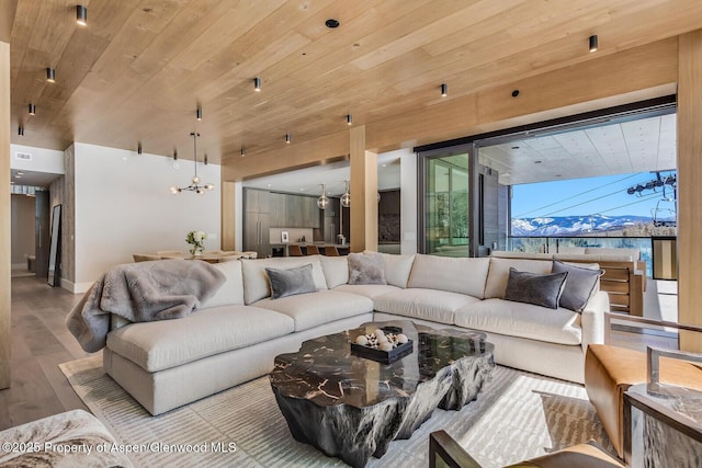 living area with baseboards, wooden ceiling, and wood finished floors
