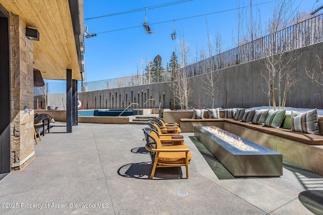 view of patio / terrace with fence and a fire pit
