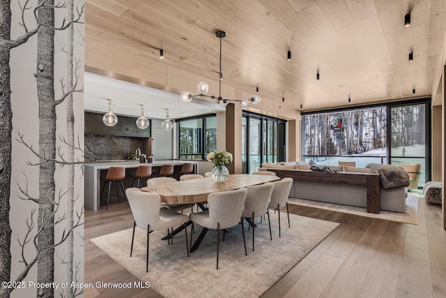 dining space with hardwood / wood-style flooring and wood ceiling