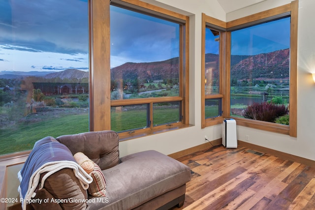 living area featuring a mountain view, wood-type flooring, and vaulted ceiling