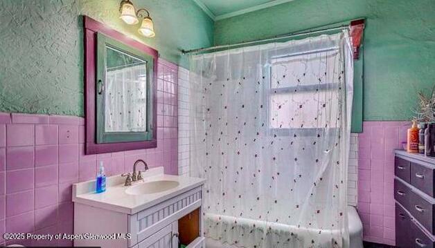 1021 Grand Ave, Glenwood Springs, CO 81601 - bathroom featuring tile walls, vanity, crown molding, and shower / bath combination with curtain