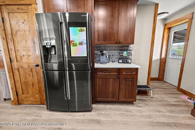 949 Breeze St, Craig, CO 81625 - kitchen with stainless steel fridge with ice dispenser, light wood-type flooring, tasteful backsplash, light countertops, and baseboards