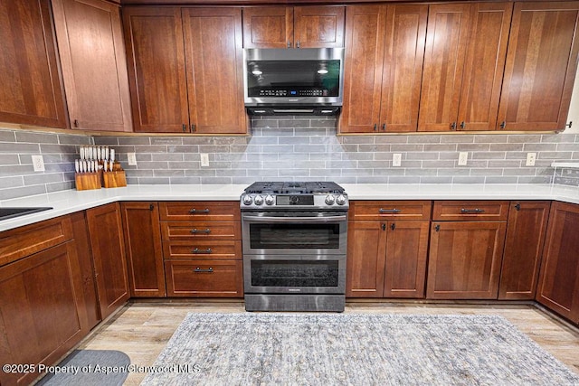 949 Breeze St, Craig, CO 81625 - kitchen featuring stainless steel appliances, light countertops, tasteful backsplash, and light wood-style floors
