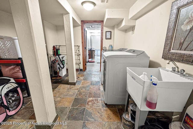 949 Breeze St, Craig, CO 81625 - washroom featuring stone tile floors, washing machine and clothes dryer, and a sink