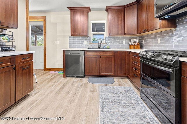 949 Breeze St, Craig, CO 81625 - kitchen featuring stainless steel dishwasher, range with two ovens, a sink, and light wood-style flooring