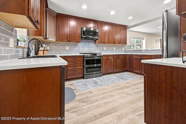 949 Breeze St, Craig, CO 81625 - kitchen with appliances with stainless steel finishes, a sink, light wood finished floors, backsplash, and recessed lighting