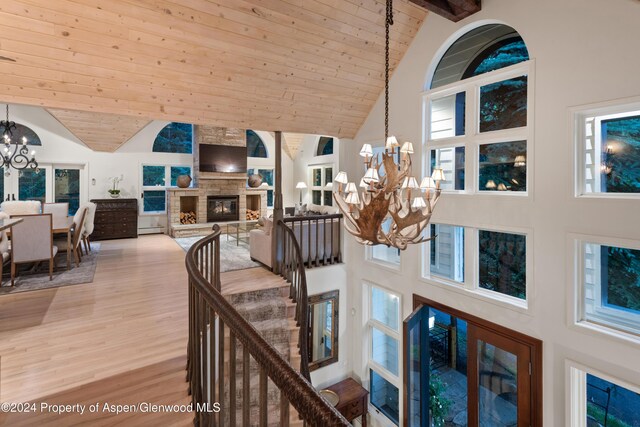 interior space with wooden ceiling, a fireplace, and high vaulted ceiling