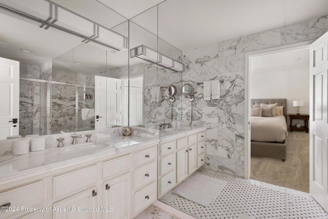 bathroom with vanity, a shower with door, and tile walls