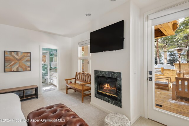 carpeted living room with a premium fireplace