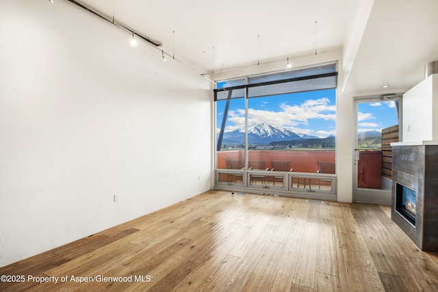 2635 Dolores Way, Carbondale, CO 81623 - interior space featuring hardwood / wood-style flooring, a mountain view, a tile fireplace, track lighting, and a wall of windows