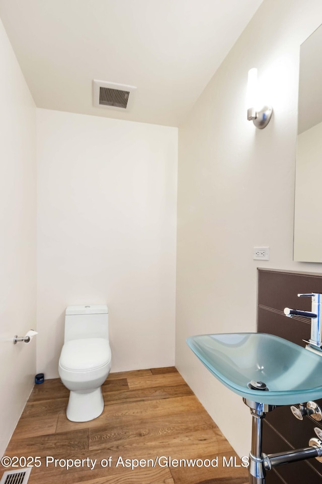 2635 Dolores Way, Carbondale, CO 81623 - bathroom with wood finished floors, visible vents, toilet, and a sink