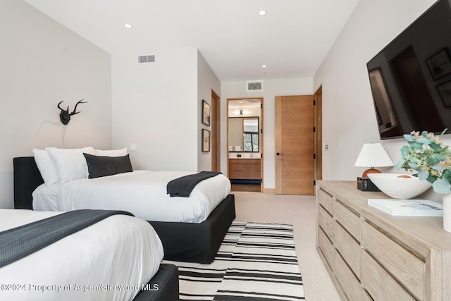 carpeted bedroom featuring ensuite bath