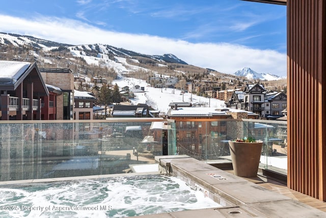 snow covered back of property with a mountain view