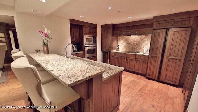 315 E Dean St Unit B52 12, 13, 15, 36, Aspen, CO 81611 - kitchen featuring stainless steel appliances, a breakfast bar area, a peninsula, light wood-type flooring, and recessed lighting