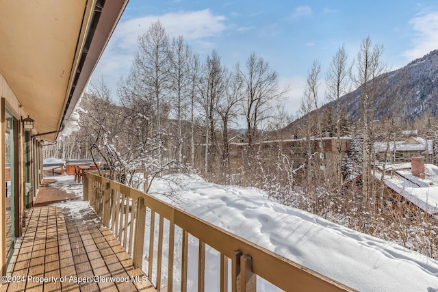 snow covered back of property featuring a mountain view