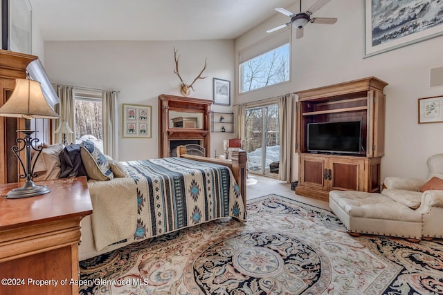 bedroom with ceiling fan, access to exterior, high vaulted ceiling, and multiple windows