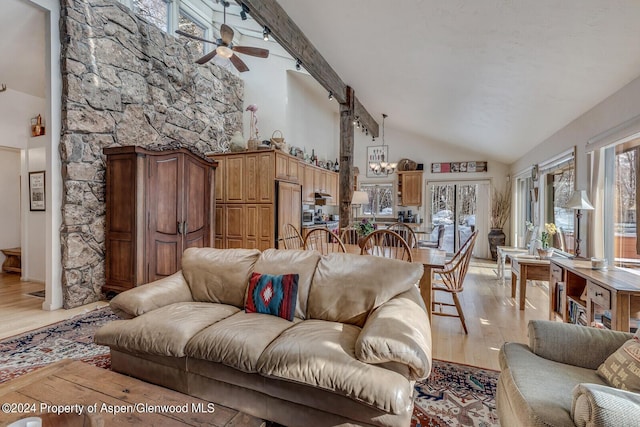 living room featuring ceiling fan with notable chandelier, high vaulted ceiling, and light hardwood / wood-style flooring