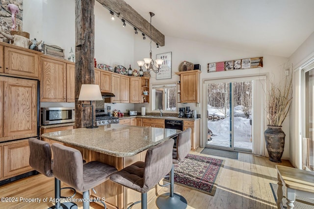 kitchen with decorative light fixtures, light wood-type flooring, a notable chandelier, light stone counters, and stainless steel appliances