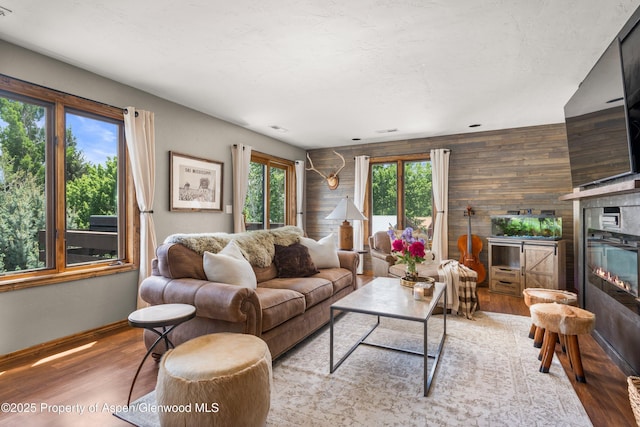 1472 W Main St, Carbondale, CO 81623 - living area with wood finished floors, wooden walls, and a glass covered fireplace
