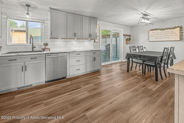 836 Ledford St, Craig, CO 81625 - kitchen featuring dishwasher, a sink, wood finished floors, gray cabinets, and a textured ceiling