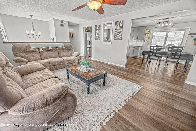 836 Ledford St, Craig, CO 81625 - living area featuring a chandelier, wood finished floors, a textured ceiling, ceiling fan, and baseboards