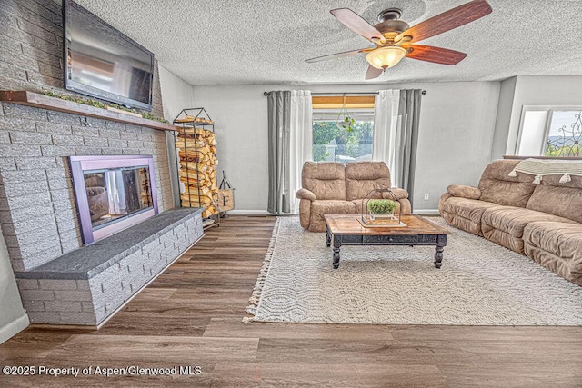 836 Ledford St, Craig, CO 81625 - living area featuring healthy amount of natural light, a ceiling fan, a fireplace, baseboards, and a textured ceiling