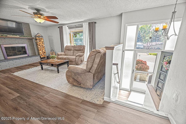 836 Ledford St, Craig, CO 81625 - living area featuring wood finished floors, ceiling fan, a textured ceiling, and a fireplace
