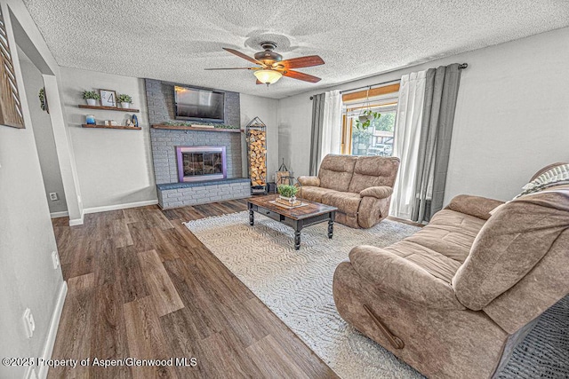 836 Ledford St, Craig, CO 81625 - living area with wood finished floors, a ceiling fan, a textured ceiling, baseboards, and a fireplace