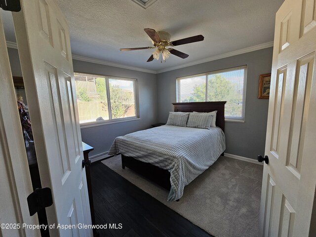 1650 Dogwood Dr, Rifle, CO 81650 - bedroom featuring baseboards, crown molding, a ceiling fan, baseboard heating, and a textured ceiling