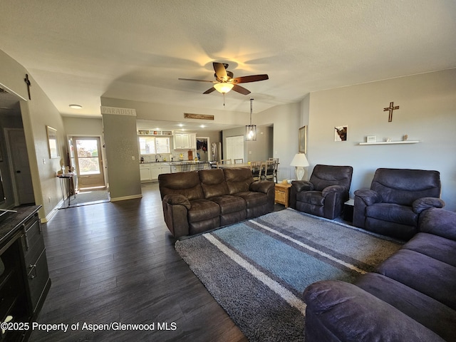 1650 Dogwood Dr, Rifle, CO 81650 - living area featuring dark wood finished floors, a ceiling fan, baseboards, and a textured ceiling