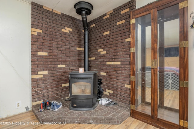 265 SW 11th Ave, Cedaredge, CO 81413 - detailed view of wood finished floors, a wood stove, brick wall, and baseboards