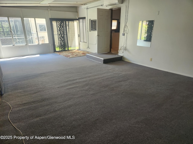 unfurnished living room with carpet flooring, a wall mounted air conditioner, and baseboards