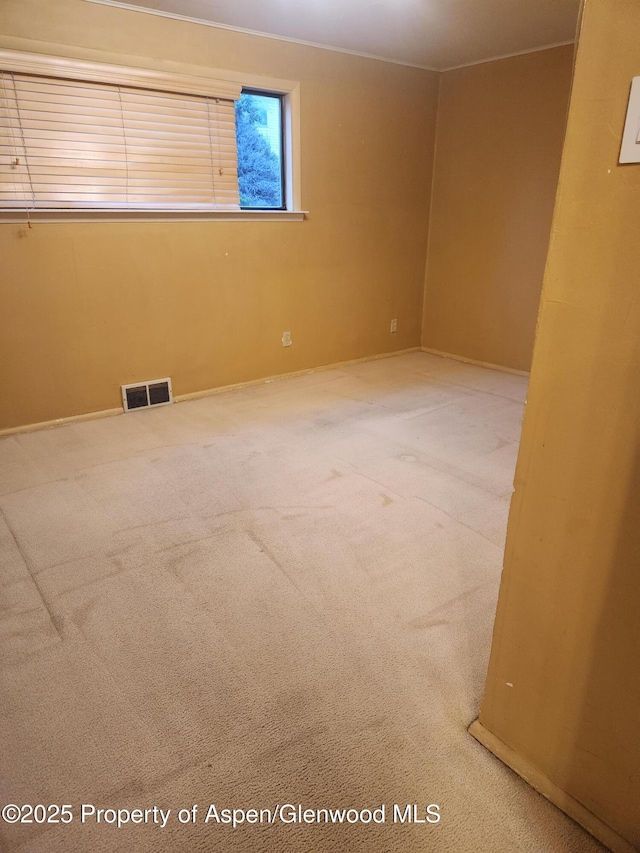 spare room with carpet and baseboards