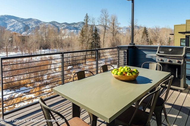 snow covered back of property featuring area for grilling and a mountain view