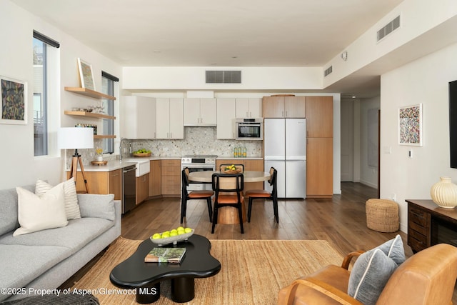 living room featuring sink and light hardwood / wood-style floors