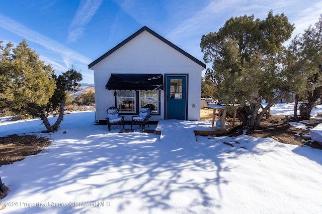 view of snow covered rear of property