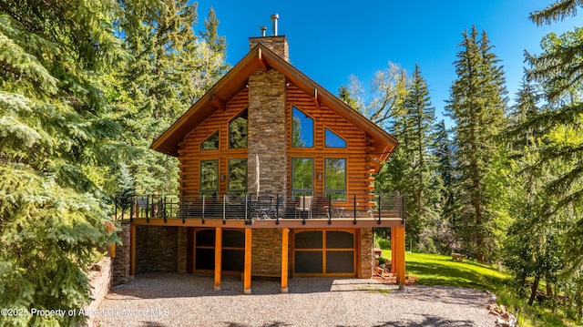 425 Crystal Park Dr, Redstone, CO 81623 - back of house with a chimney, stone siding, log exterior, gravel driveway, and a deck
