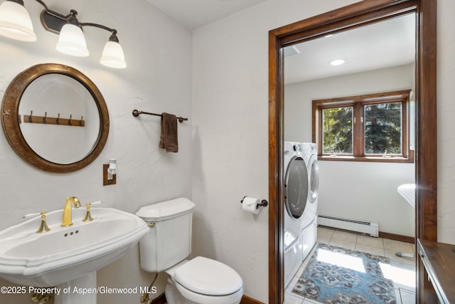 425 Crystal Park Dr, Redstone, CO 81623 - bathroom featuring a baseboard heating unit, toilet, separate washer and dryer, tile patterned flooring, and a sink