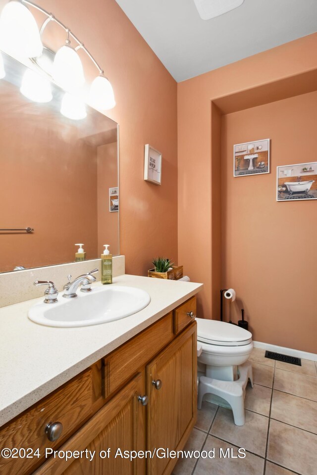 bathroom featuring toilet, vanity, and tile patterned floors