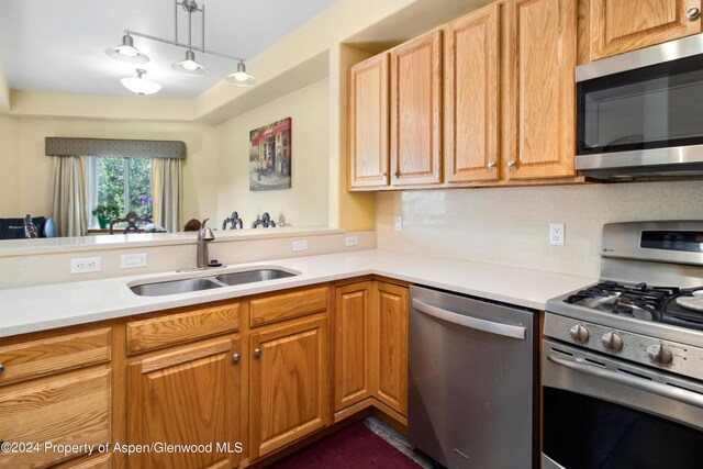 kitchen with pendant lighting, sink, and appliances with stainless steel finishes