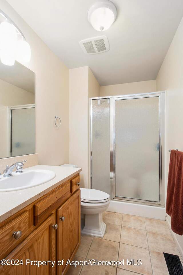 bathroom with walk in shower, tile patterned flooring, vanity, and toilet